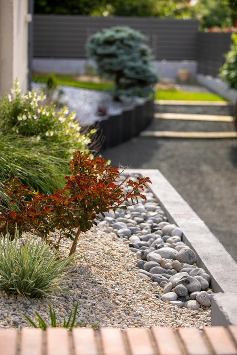 Main d'architecte paysagiste dessinant un plan d'aménagement extérieur coloré avec crayon bleu