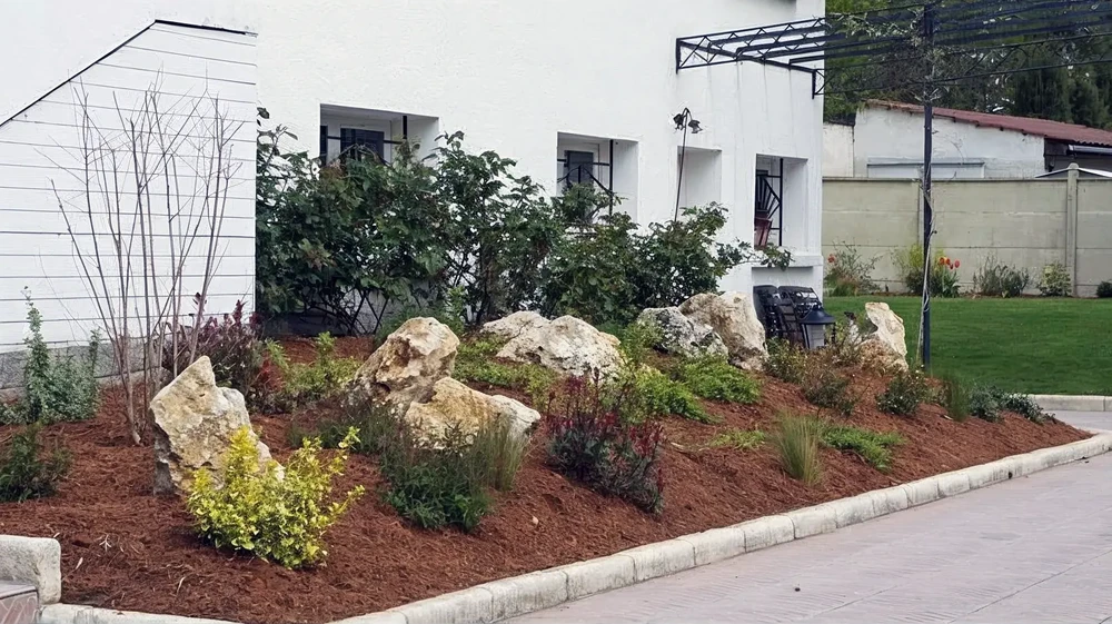 Aménagement paysager extérieur résidentiel avec massif rocheux décoratif