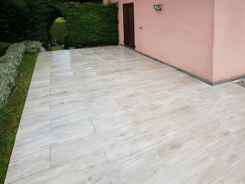 Aménagement paysager extérieur résidentiel avec allée courbe en pavés autobloquants beiges et roses