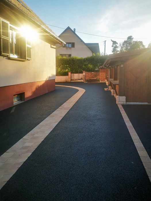 Jardin résidentiel avec allée pavée en briques traversant un espace paysager aménagé