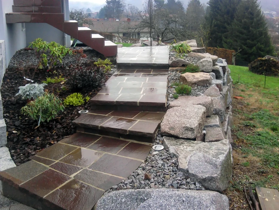 Jardin paysager avec allée pavée serpentant entre parterres fleuris